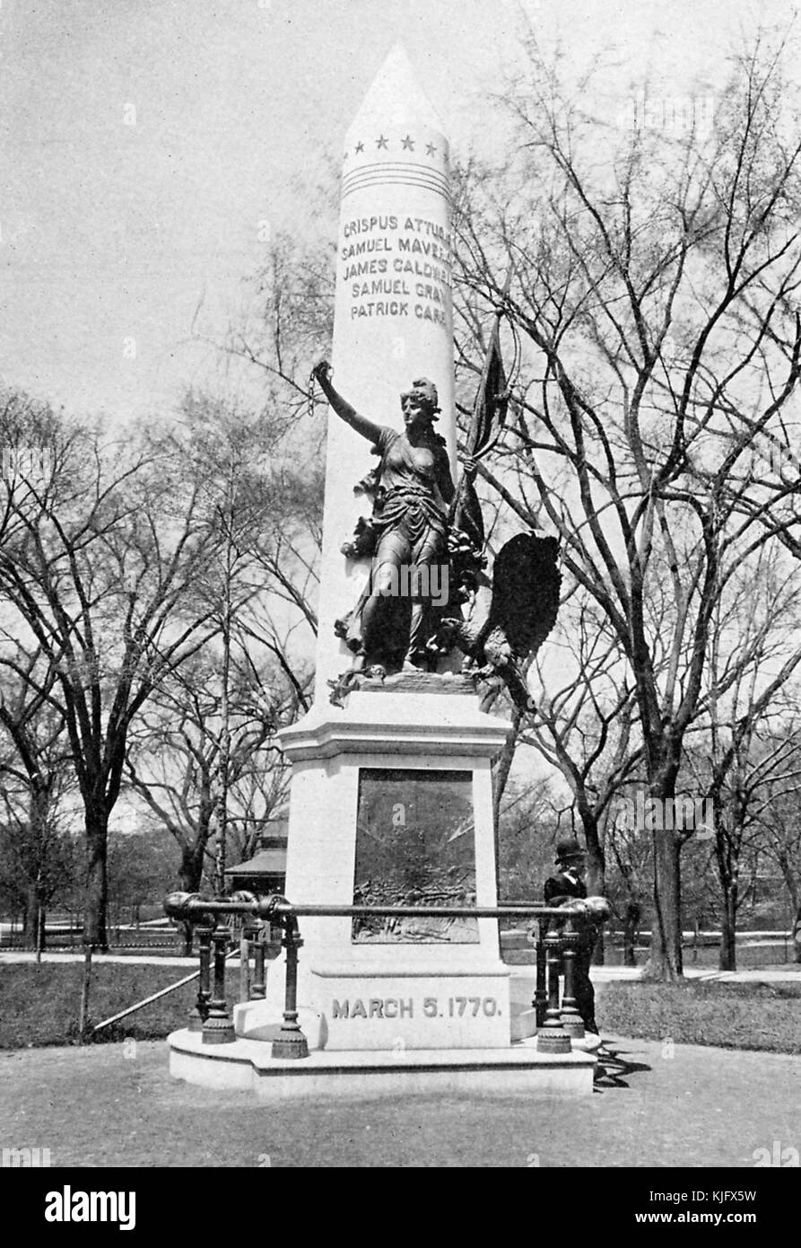 A photograph of the Boston Massacre Monument, the monument was constructed in 1888 as a memorial to the victims of the Boston Massacre, the names of the five men killed in the attack are engraved on the central tower of the monument, a statue on the monument represents liberty and she holds a broken chain and a flag, a man can be seen standing near the monument in the photo, Boston, Massachusetts, 1905. Stock Photo