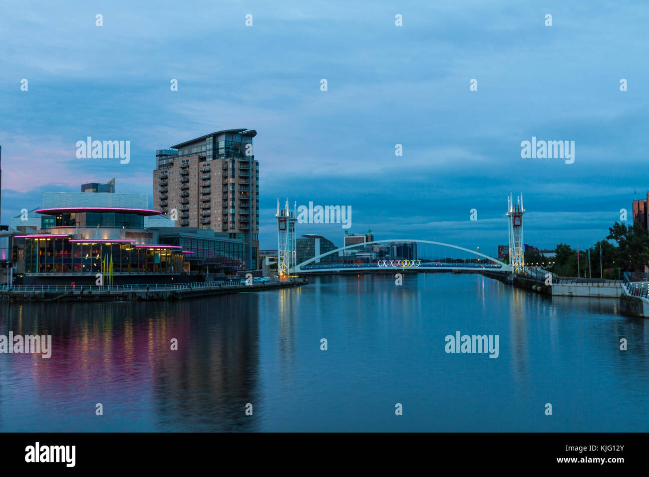 Image of the Lowry Theatre and Lowry Art Gallery taken from the Manchester Ship Canal in the early evening with the Millennium Bridge in background. Stock Photo