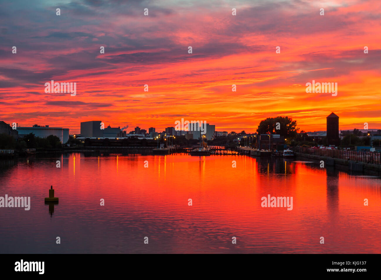 A Spectacular Sunset and Red Sky reflected in the Manchester Ship Canal at Salford Quays. Stock Photo