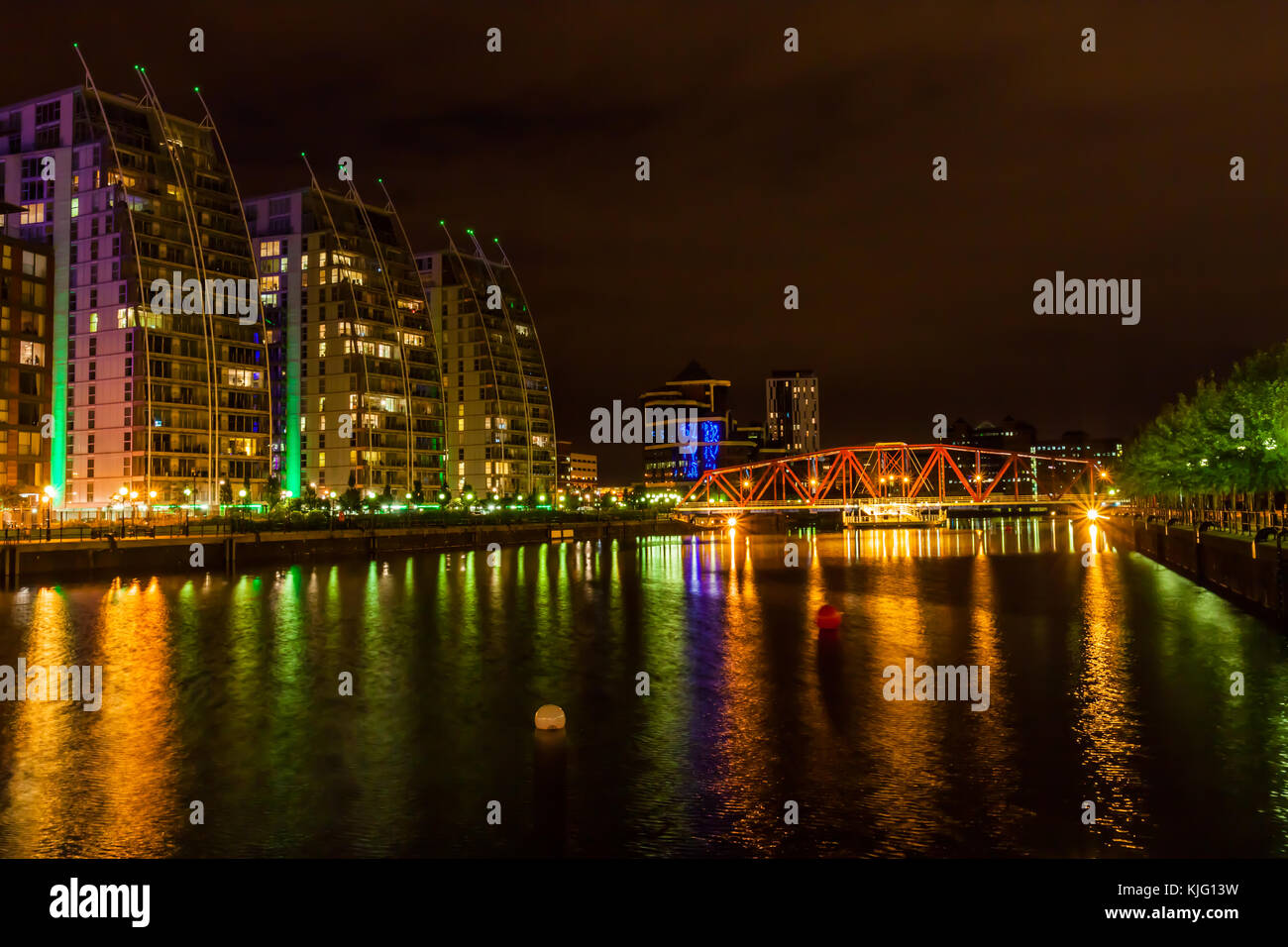The Huron Basin at Salford Quays with the NV apartment buildings and swing bridge lit against the night sky. Stock Photo