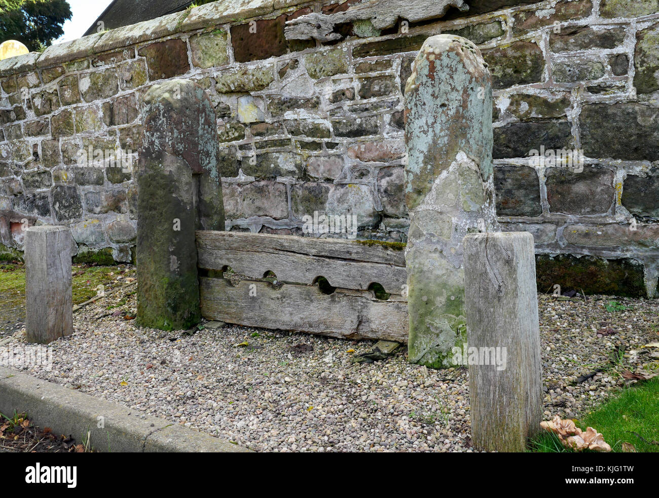 Ancient punishment stocks outside Chapel of Saint Luke, Western Under Redcastle, Shropshire, England, UK. Stock Photo