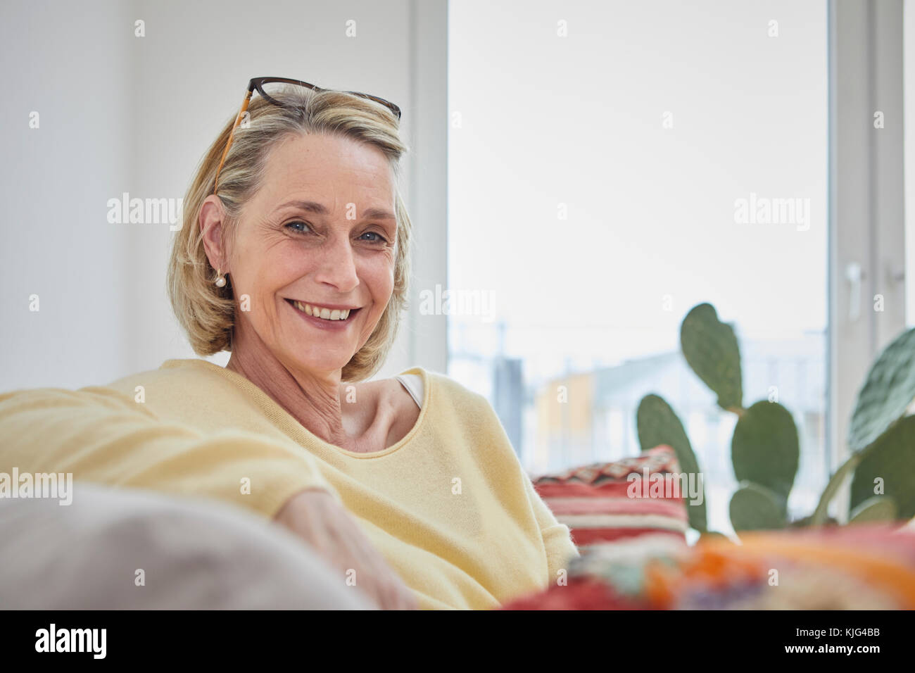 Portrait of smiling mature woman at home on the sofa Stock Photo - Alamy