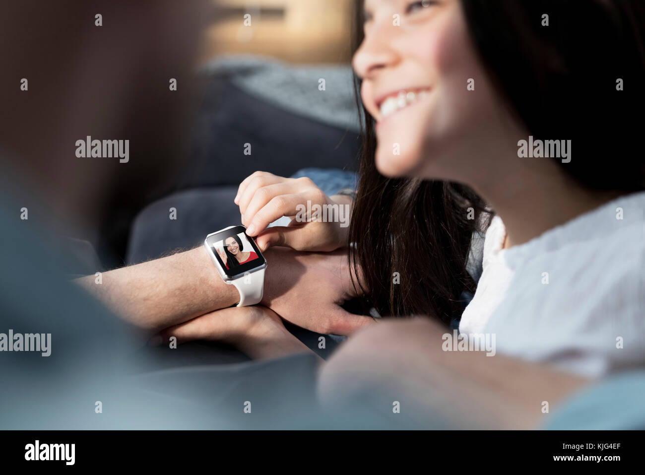 Daughter and father with smartwatch with mother waving Stock Photo