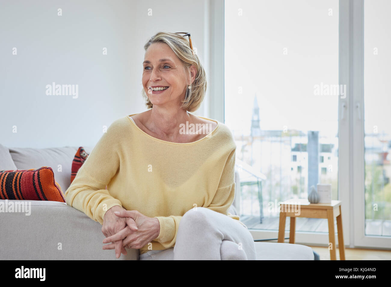 Portrait of smiling mature woman at home on the sofa Stock Photo - Alamy