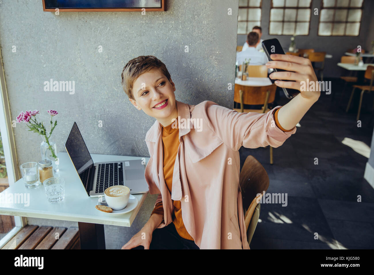 Woman taking a selfie with coffee and laptop in cafe Stock Photo - Alamy