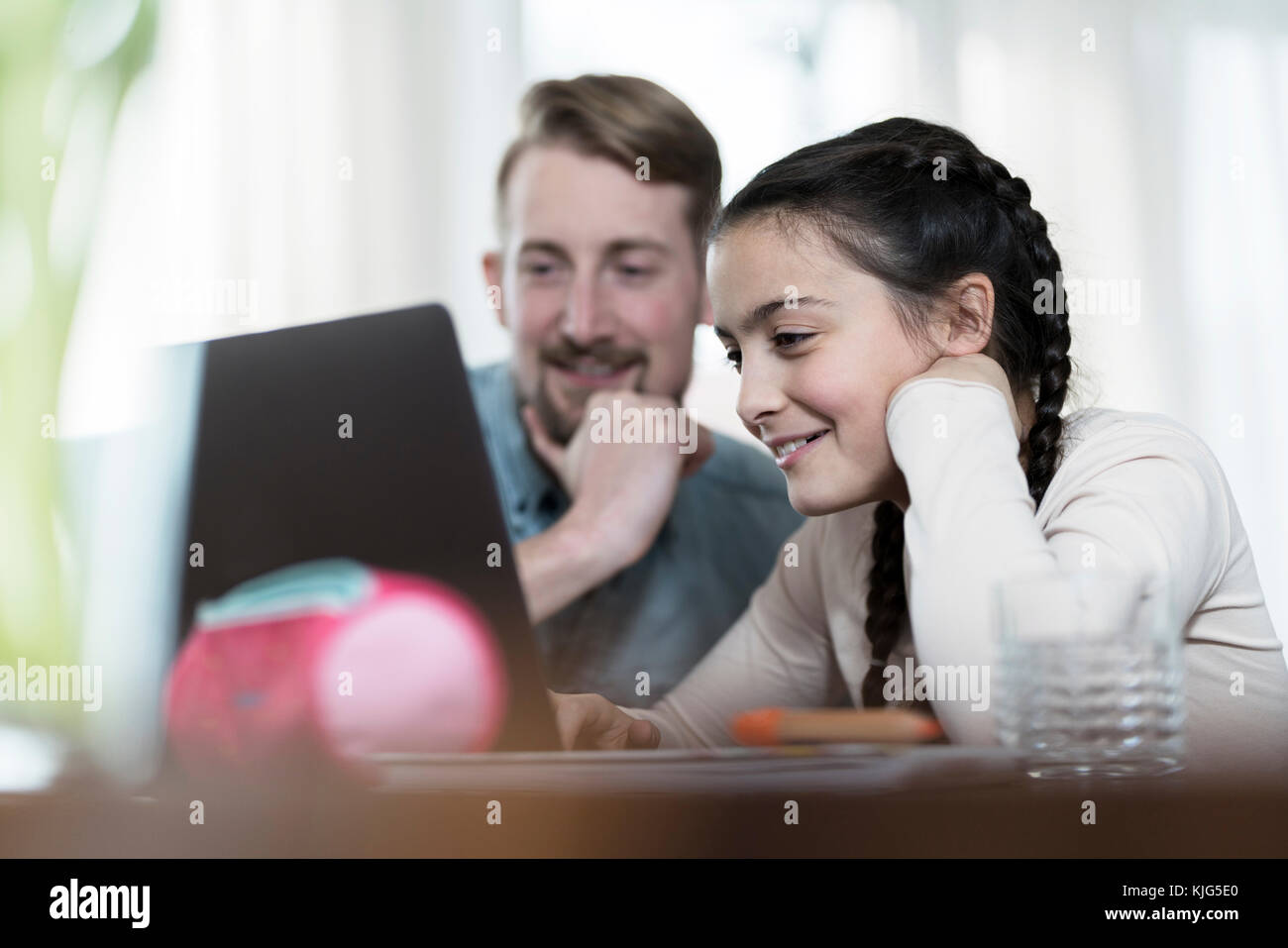 Father and daughter looking at laptop together Stock Photo