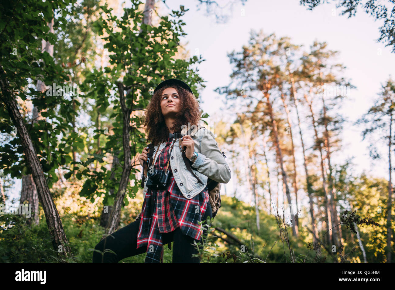 Portrait of teenage girl with camera and backpack in nature Stock Photo ...