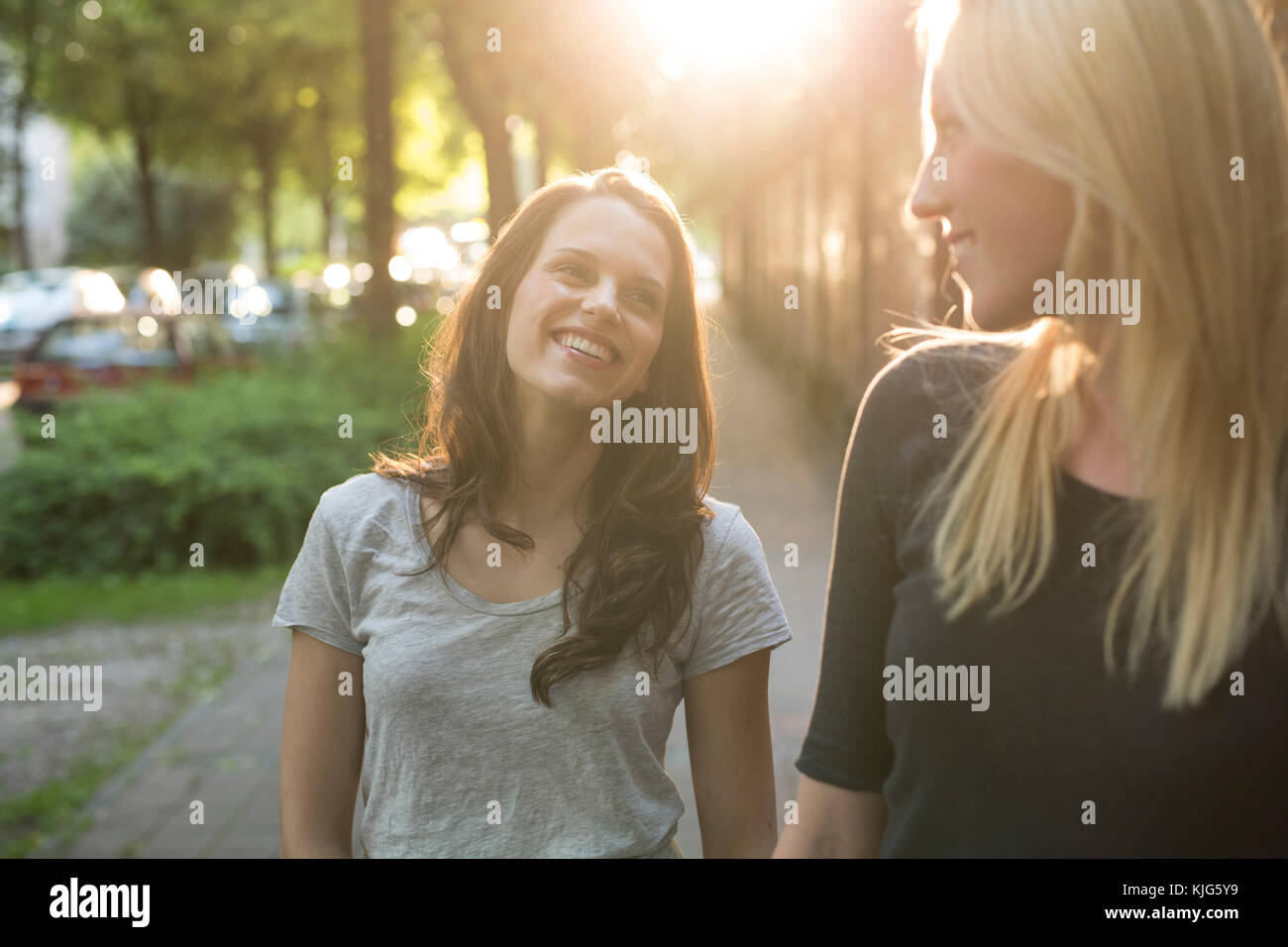 Two happy young women outdoors at sunset Stock Photo - Alamy