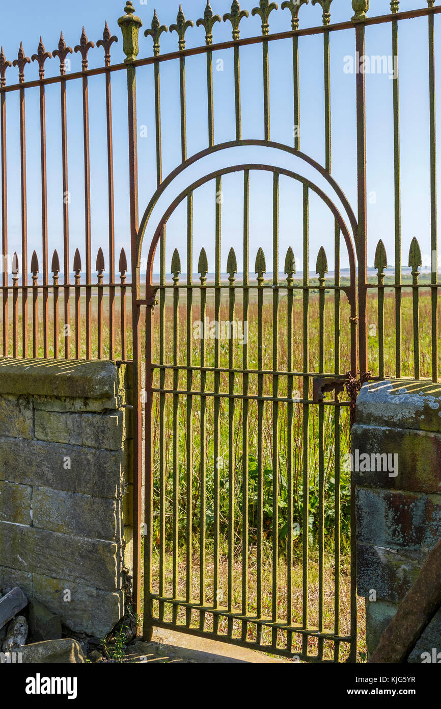 Iron gateway within the framework of a wrought iron fence and traditional stone wall, Wigtown, Scotland, UK. Stock Photo