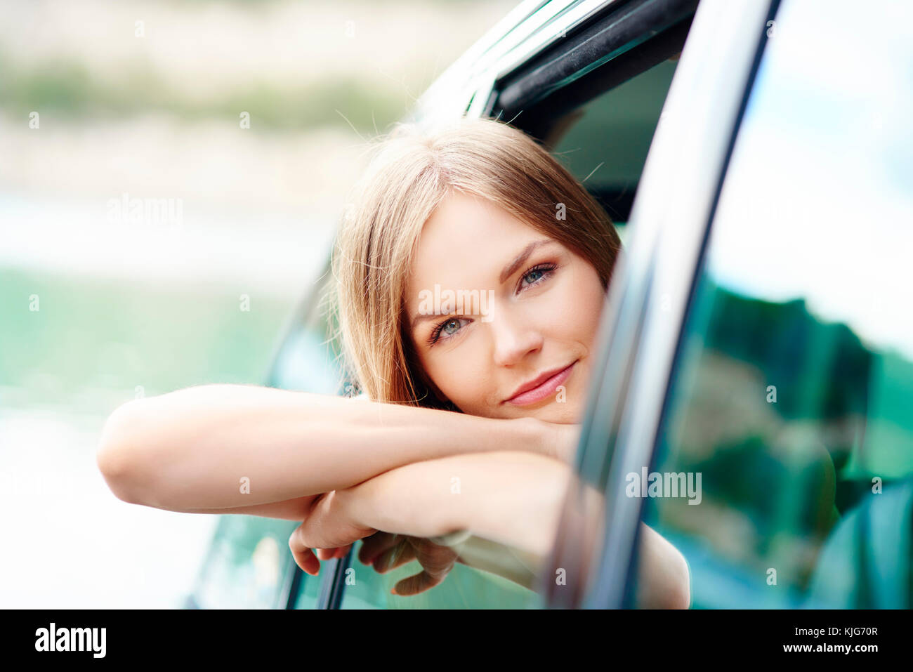 Smiling blonde in car seeing from outside, Krakow, Malopolskie, Poland Stock Photo