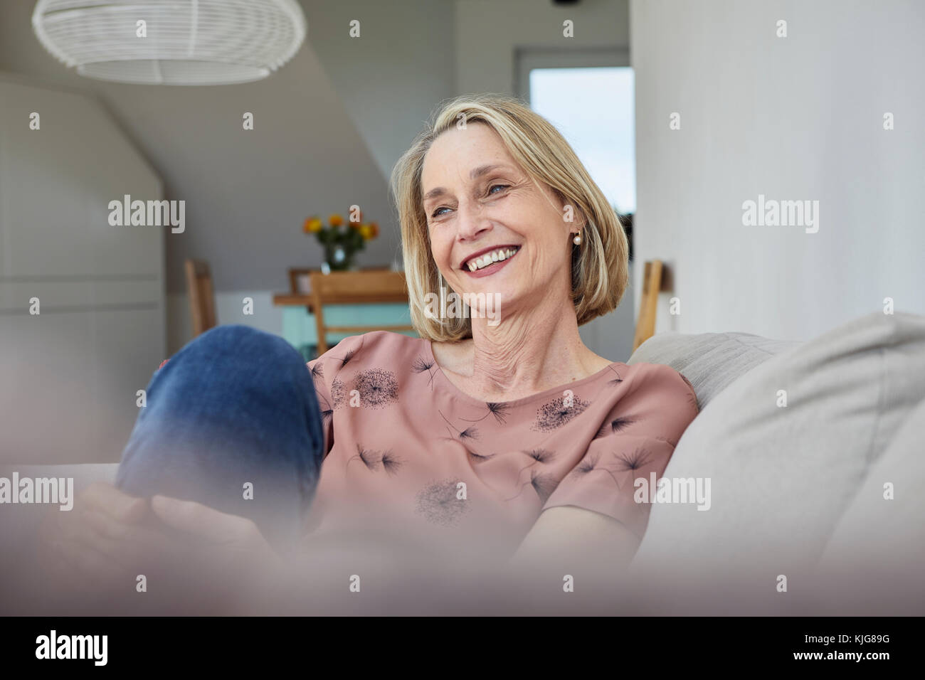 Smiling mature woman at home on the sofa Stock Photo - Alamy