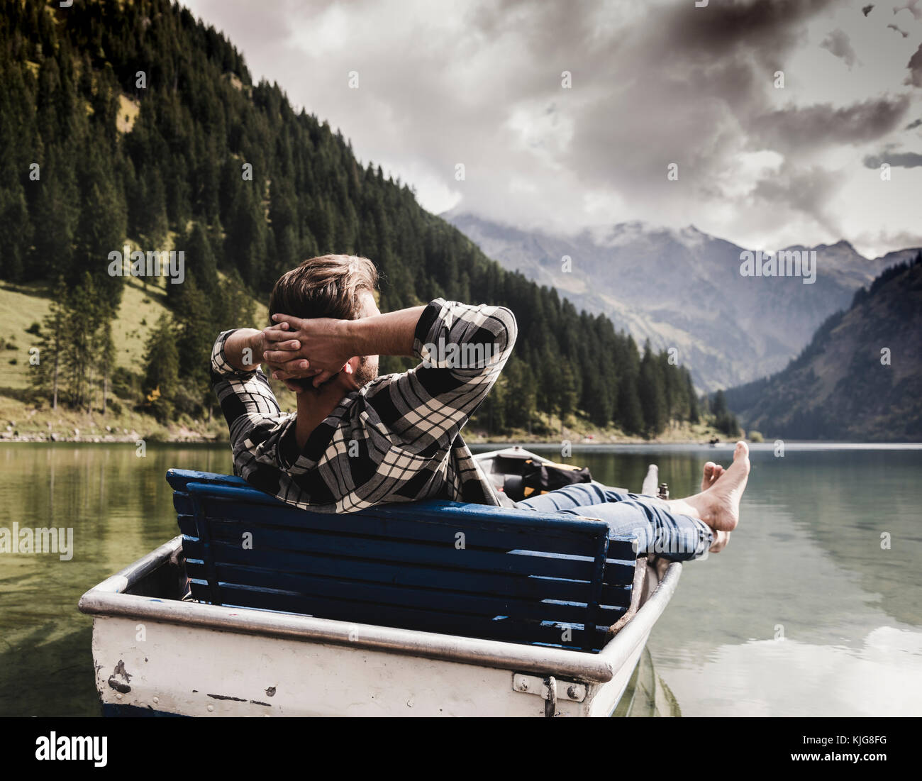 Austria, Tyrol, Alps, relaxed man in boat on mountain lake Stock Photo