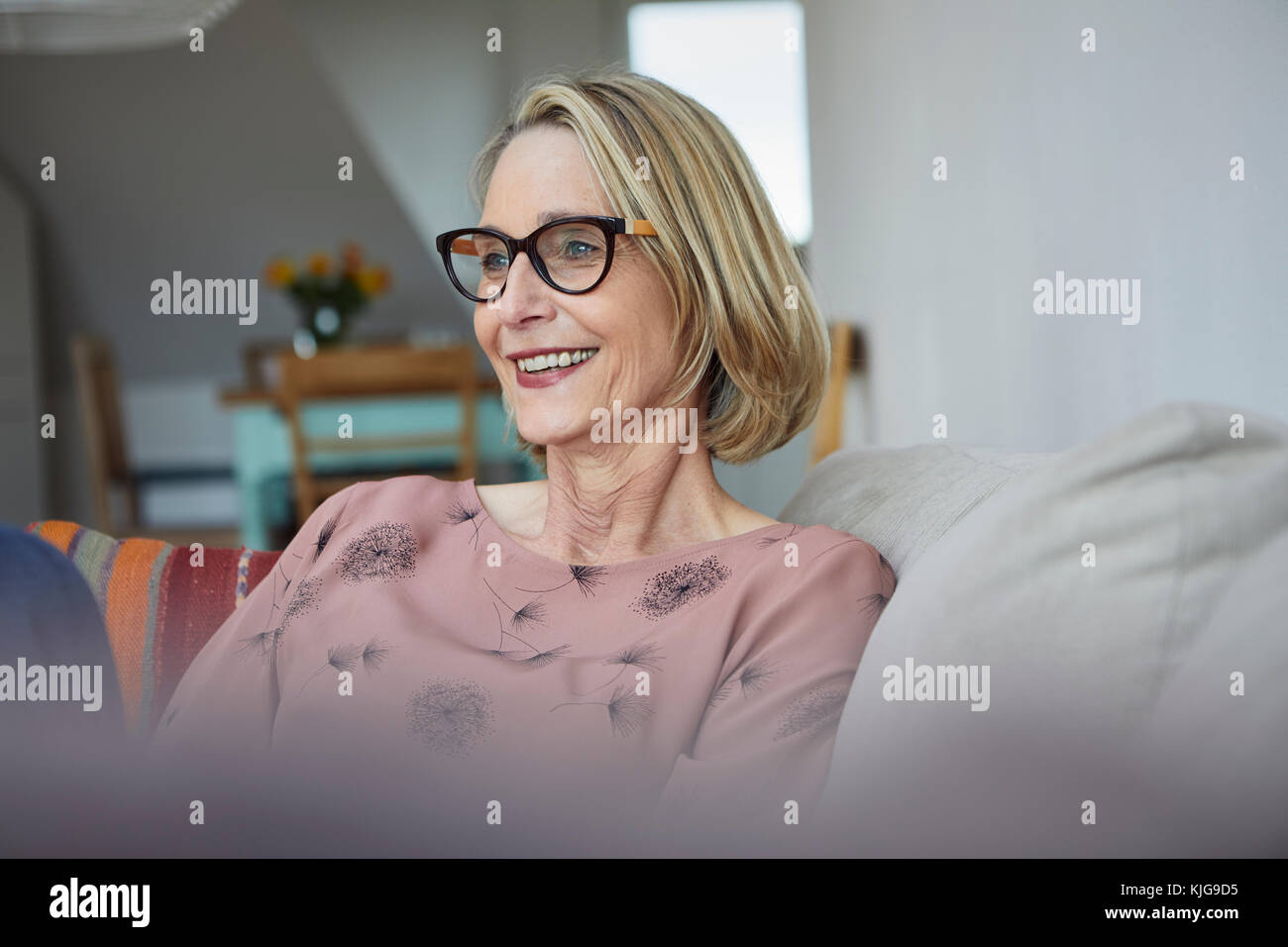 Smiling mature woman at home on the sofa Stock Photo - Alamy