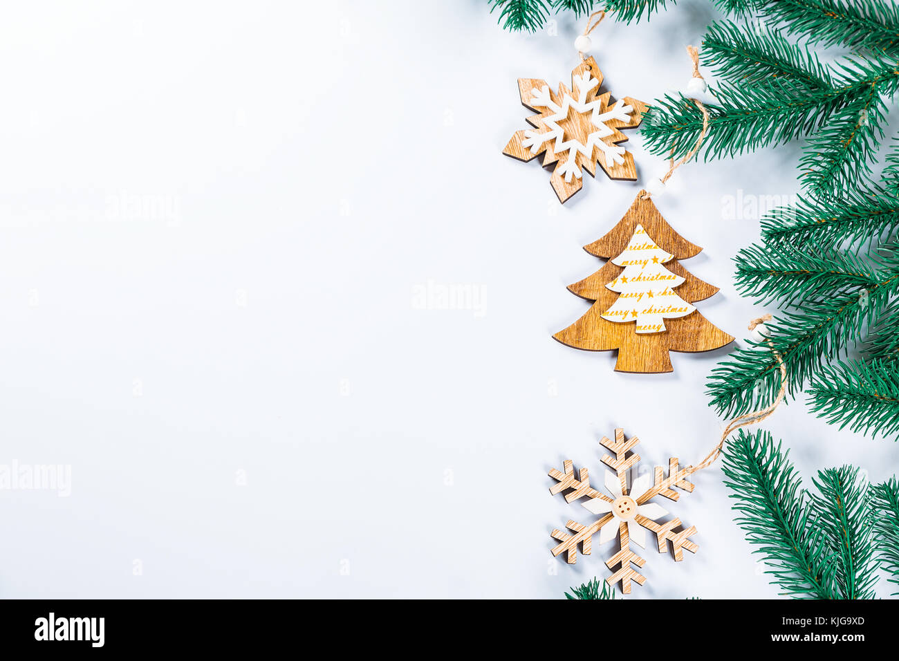 Christmas frame with the branches of the Christmas tree and wooden  decorations on white background. Simple Christmas composition with free  space Stock Photo - Alamy