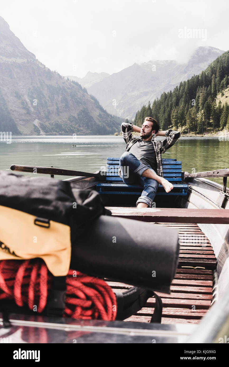 Austria, Tyrol, Alps, relaxed man in boat on mountain lake Stock Photo