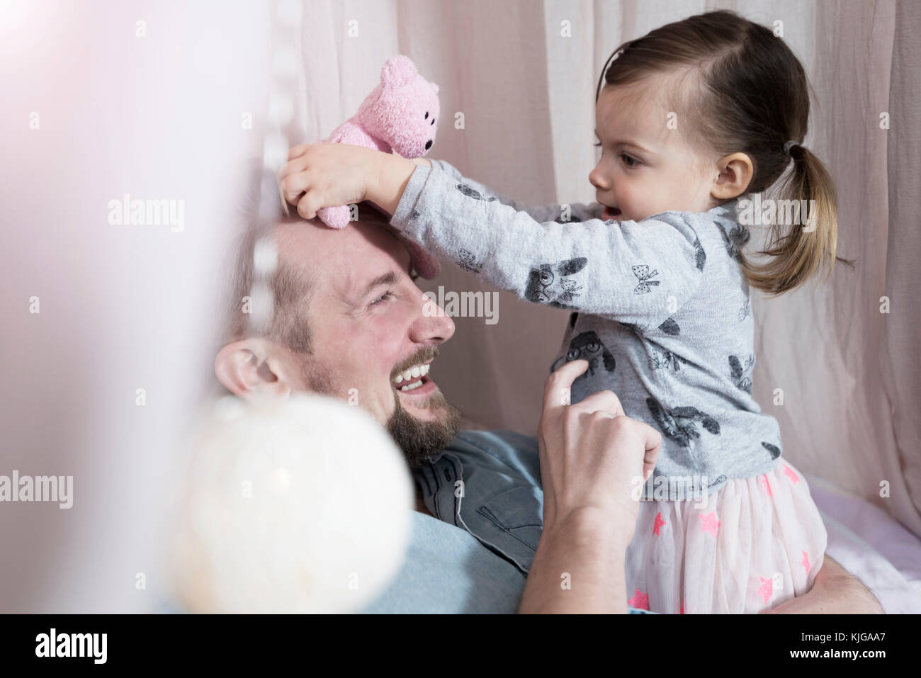 Happy father playing with toddler daughter in toy teepee Stock Photo