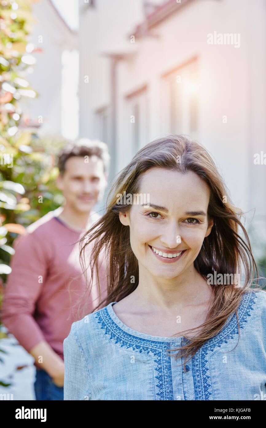 Portrait of smiling woman with man in background Stock Photo - Alamy