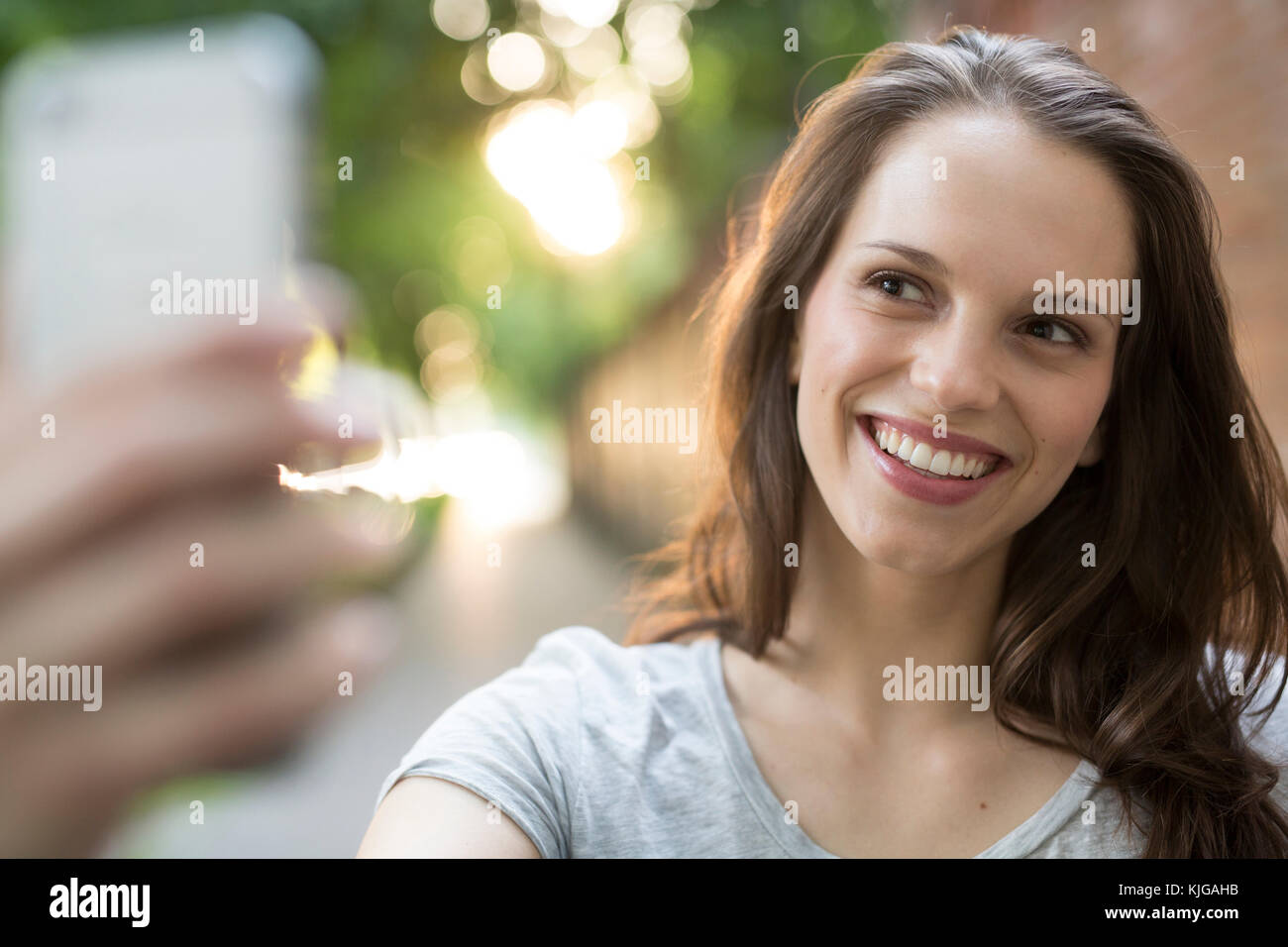 Portrait of happy young woman outdoors taking a selfie Stock Photo - Alamy