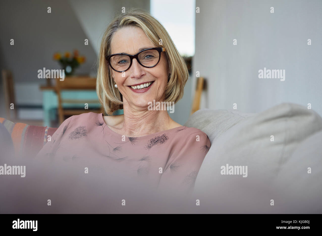 Portrait of smiling mature woman at home on the sofa Stock Photo - Alamy