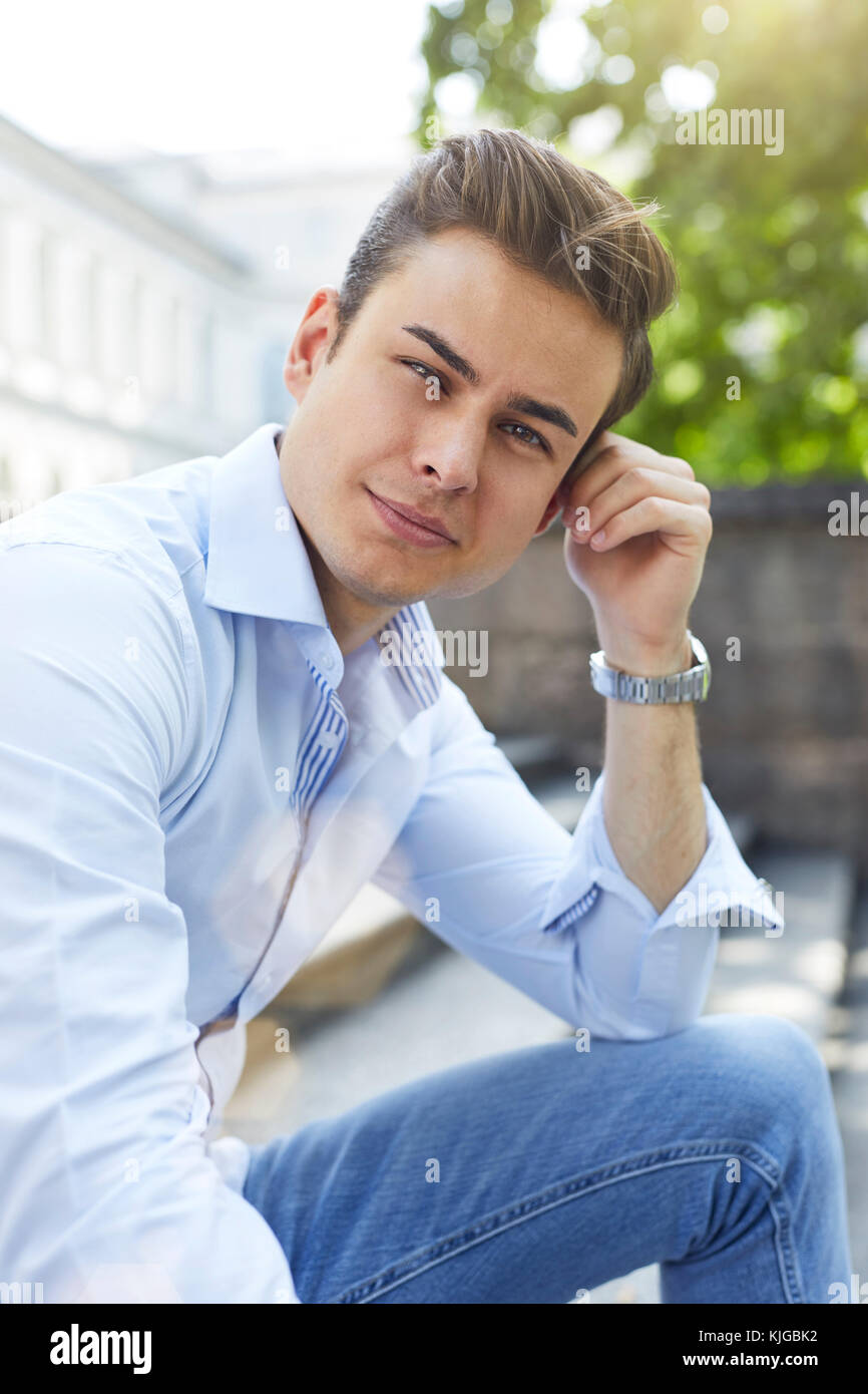 Portrait of pensive young man sitting on stairs Stock Photo - Alamy