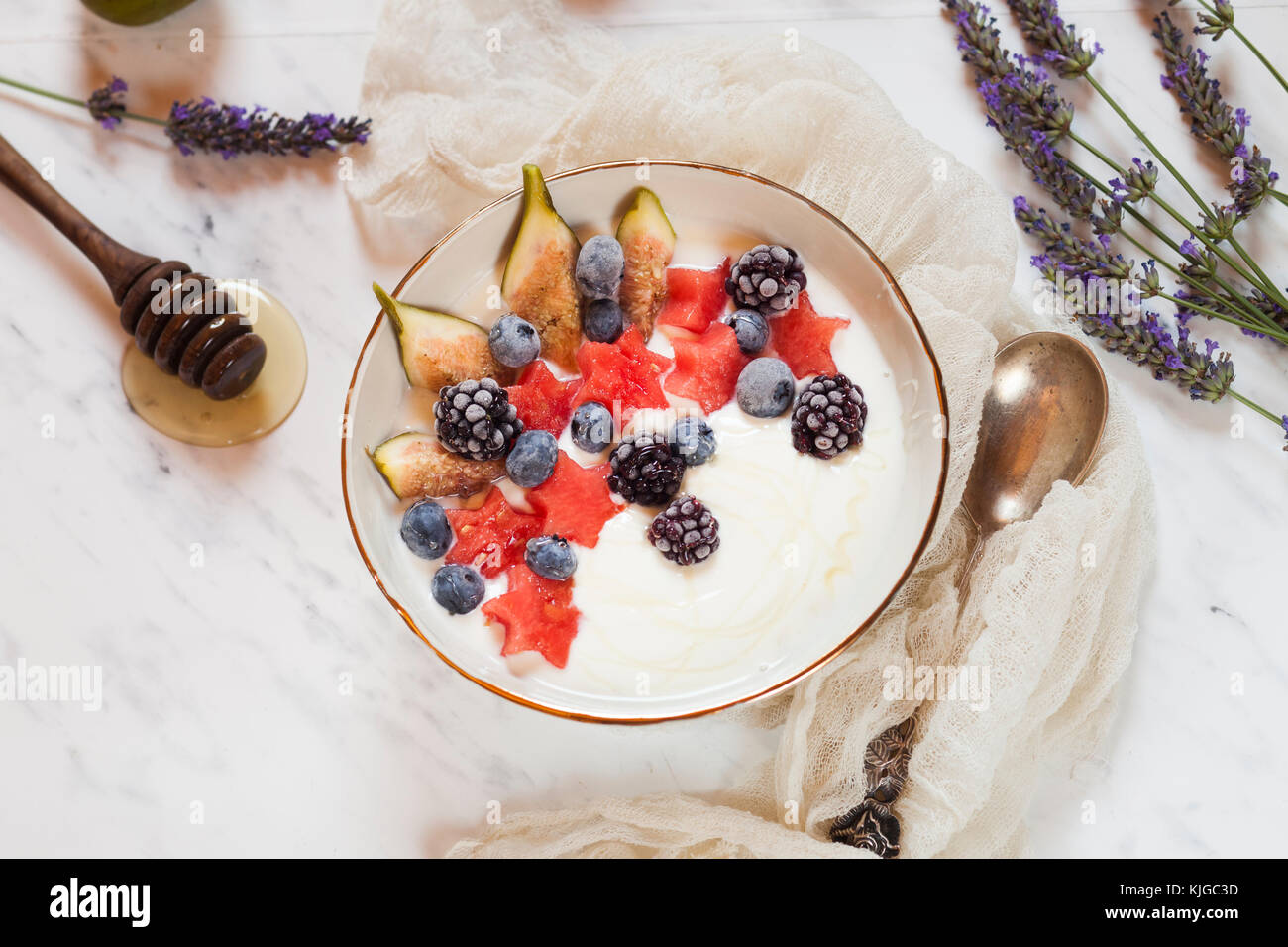 Bowl of Greek yoghurt with fig, watermelon, frozen berries and lavender