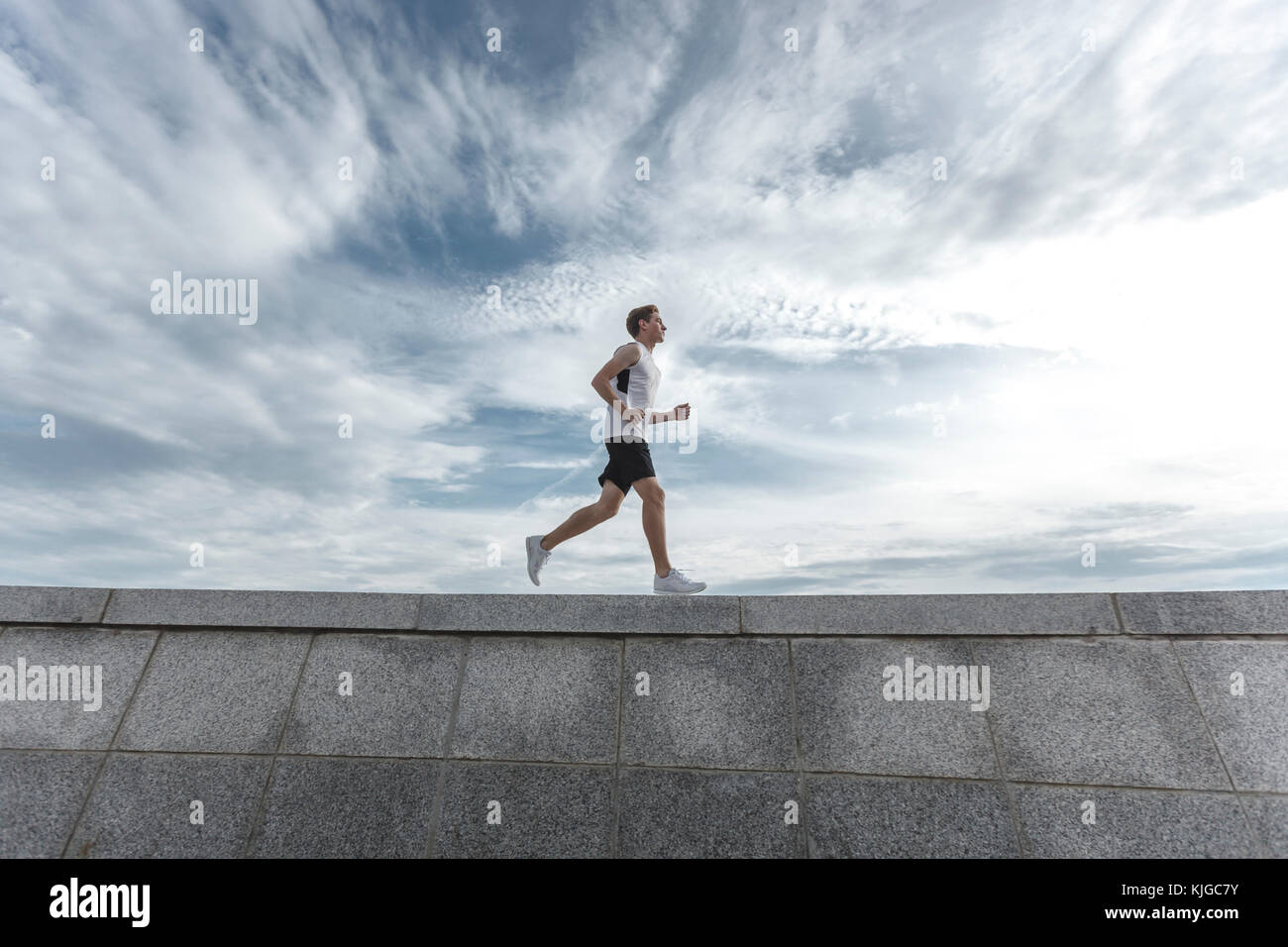 Young man running on wall Stock Photo Alamy