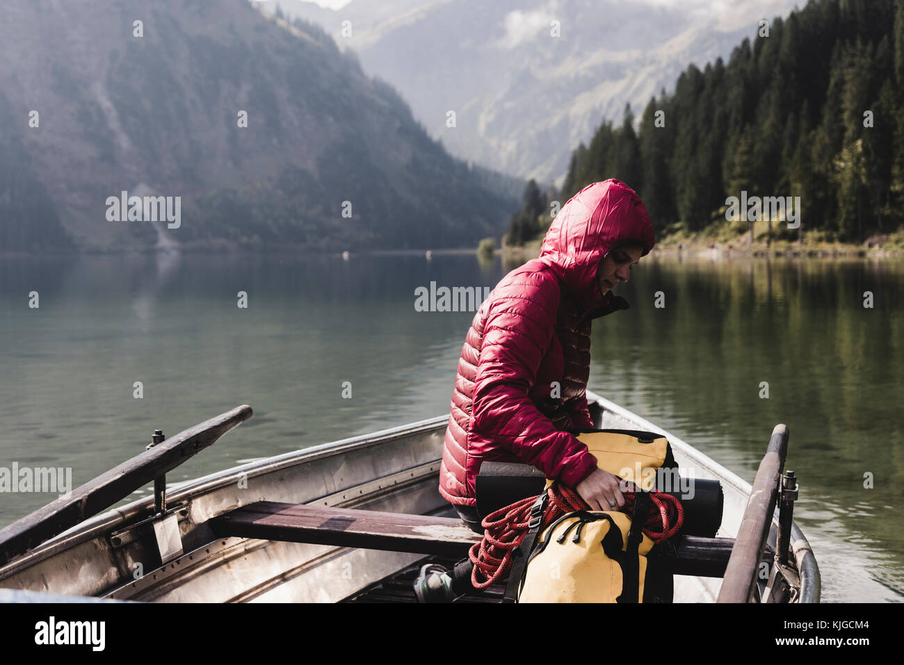 Austria, Tyrol, Alps, woman with backpack in boat on mountain lake Stock Photo
