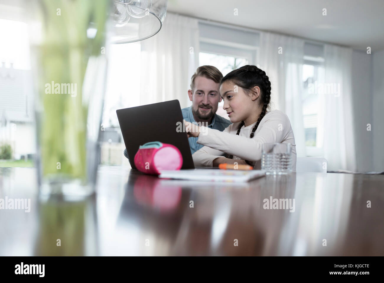Father and daughter looking at laptop together Stock Photo