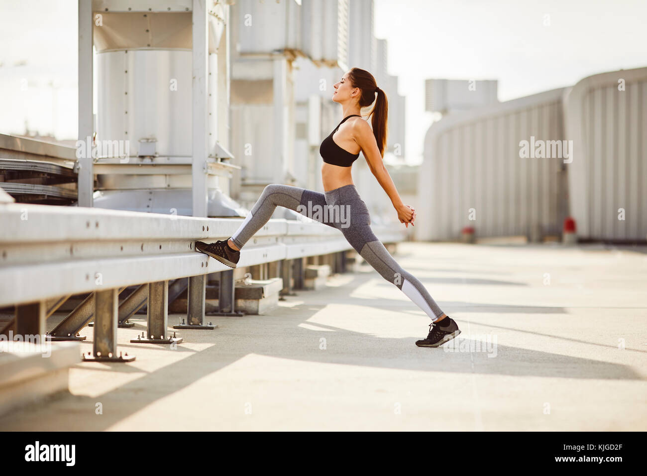 Young woman stretching during city workout Stock Photo - Alamy
