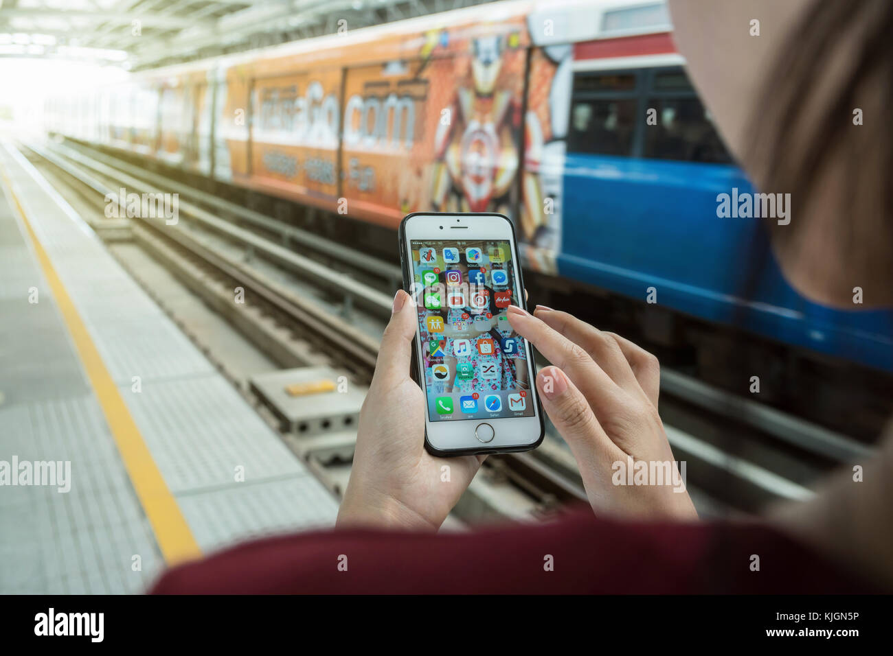 BANGKOK, THAILAND - JUNE 2, 2016: Closeup rear view of woman hand in Iphone6 white color on the application screen in the BTS Skytrain rails for trave Stock Photo