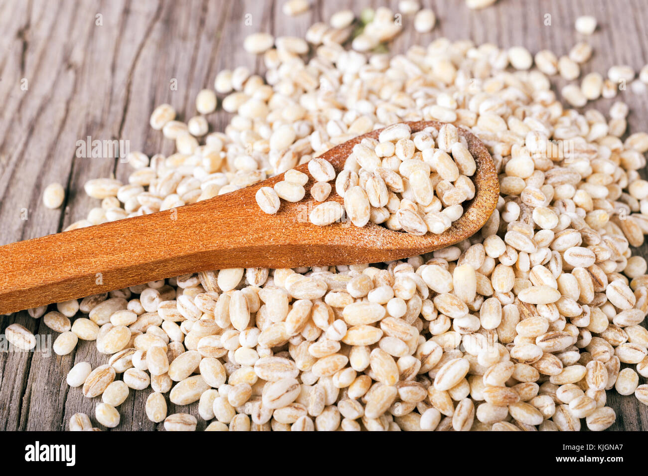 Pearl barley grains in wooden spoon Stock Photo