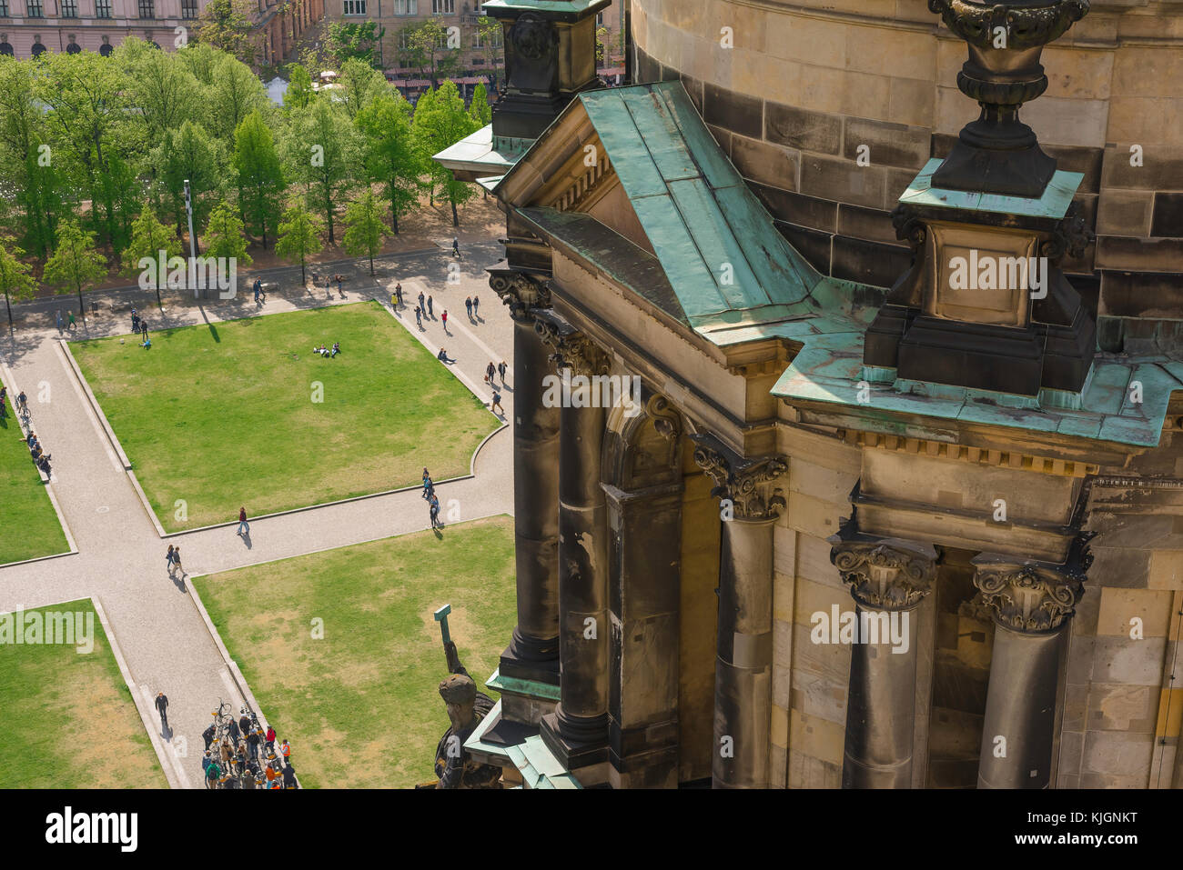 Berlin cathedral, view below the Berliner Dom's north transept as people cycle or stroll through the Lustgarten park on a summer day, Berlin, Germany. Stock Photo