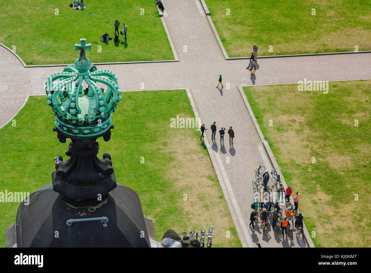 Lustgarten Park, below one of Berlin cathedral's crown-topped towers people cycle or stroll through the Lustgarten park, Germany. Stock Photo