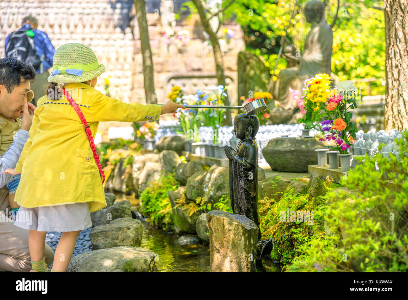Child worshiping Jizo Statue Stock Photo