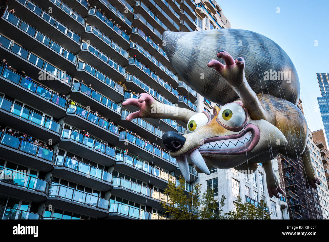 New York, USA. 23rd Nov, 2017. New York, USA, A balloon of Ice Age's Scrat participates in the 2017 Macy's Thanksgiving Day parade as spectators watch from their balconies overlooking New York's Central Park South. Credit: Enrique Shore/Alamy Live News Stock Photo