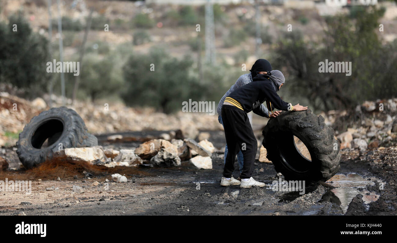 Nablus, West Bank, Palestinian Territory. 24th Nov, 2017. Palestinian protesters roll a tire during clashes with Israeli security forces following a weekly demonstration against the expropriation of Palestinian land by Israel in the village of Kfar Qaddum, near Nablus in the occupied West Bank, on November 24, 2017 Credit: Shadi Jarar'Ah/APA Images/ZUMA Wire/Alamy Live News Stock Photo