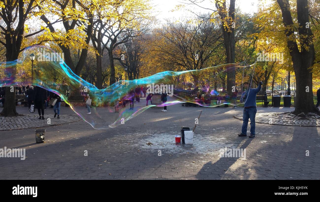 New York, United States. 24th Nov, 2017. A man blows large bubbles in New York's Central Park as children and onlookers watch on a beautiful autumn day, November 24, 2017 Credit: Adam Stoltman/Alamy Live News Stock Photo