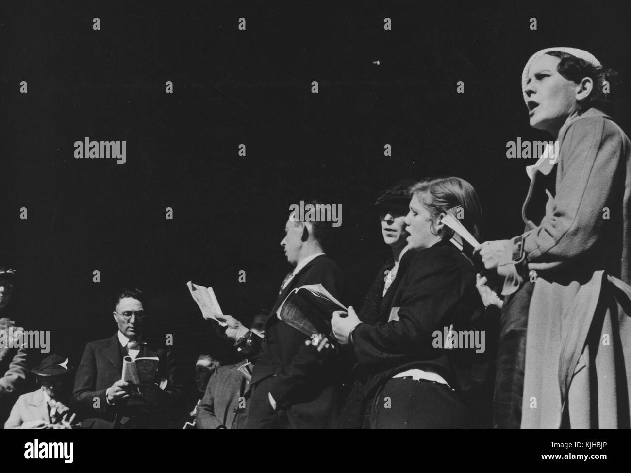 A photograph of a group of men and women are gathered together as part of a religious meeting, they are holding hymnals and singing hymns towards an audience that is not shown, Nashville, Tennessee, 1935. From the New York Public Library. Stock Photo