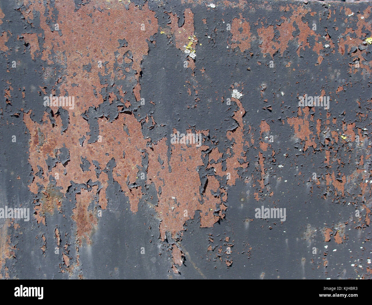 Brown rusty metal sheet with peeling black paint surface texture