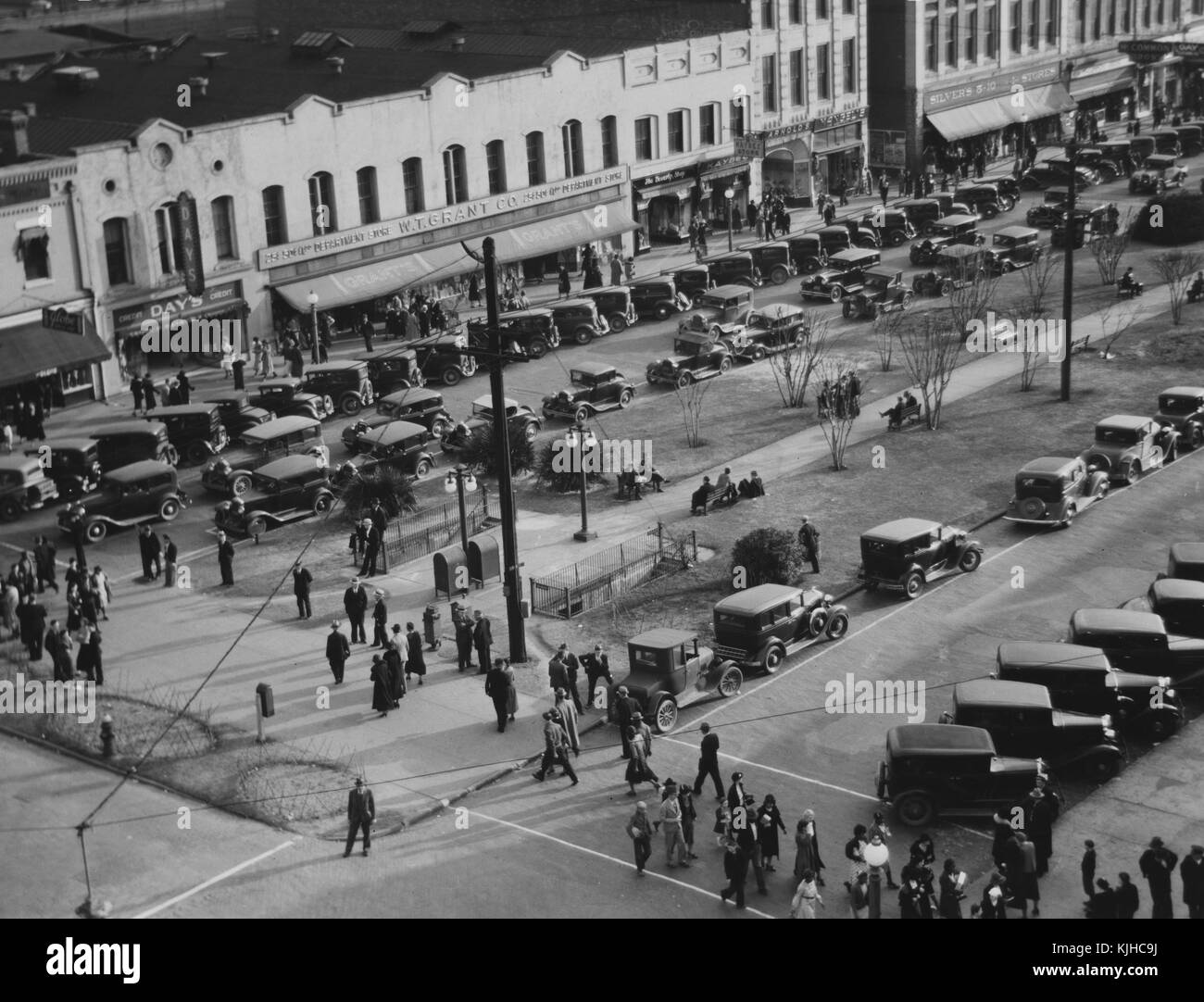 Black and white photograph of a Main Street, many cars parked along the street, people walking across the road, by Walker Evans, American photographer known for his work for the Farm Security Administration documenting the effects of the Great Depression, Macon, Georgia, 1936. From the New York Public Library. Stock Photo