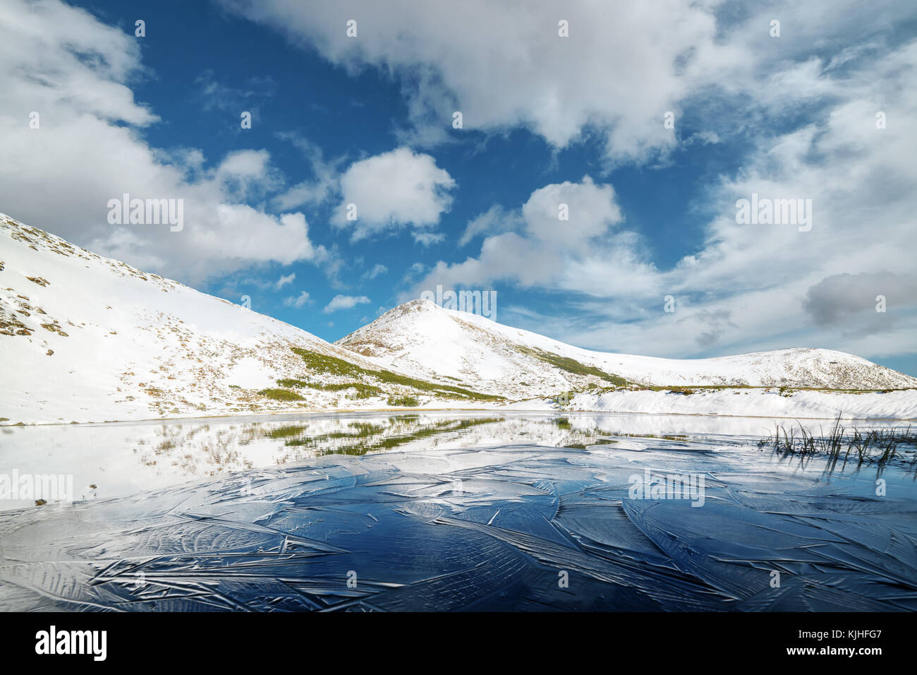 Frozen mountain lake with blue ice Stock Photo