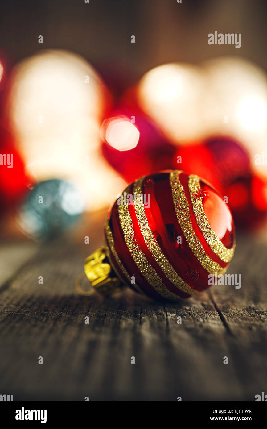 Red Christmas Bauble On Rustic Wooden Board Soft Bokeh Lights In