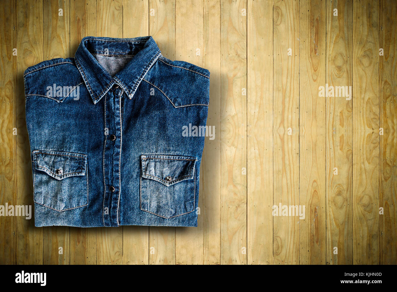 Top view of jeans shirt put on wooden table background Stock Photo
