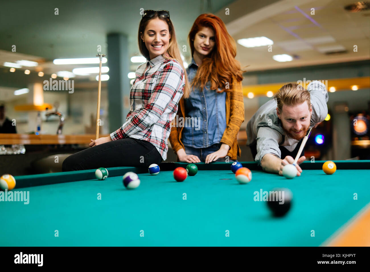 Happy friends enjoying playing pool Stock Photo - Alamy