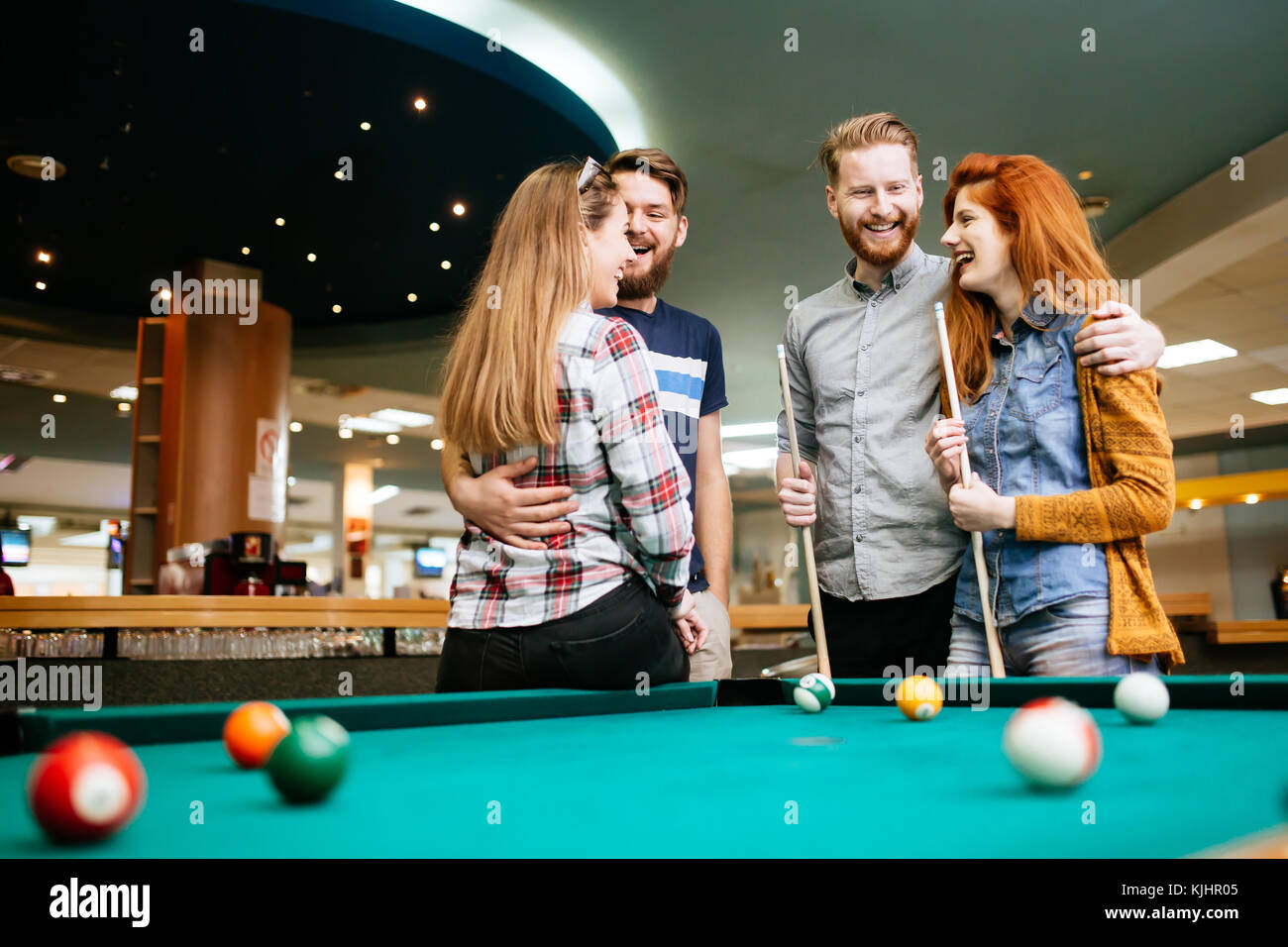 Happy friends enjoying playing pool Stock Photo - Alamy