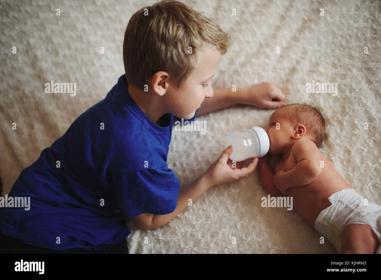https://c8.alamy.com/comp/KJHRN5/boy-feeding-newborn-baby-with-bottle-of-milk-KJHRN5.jpg