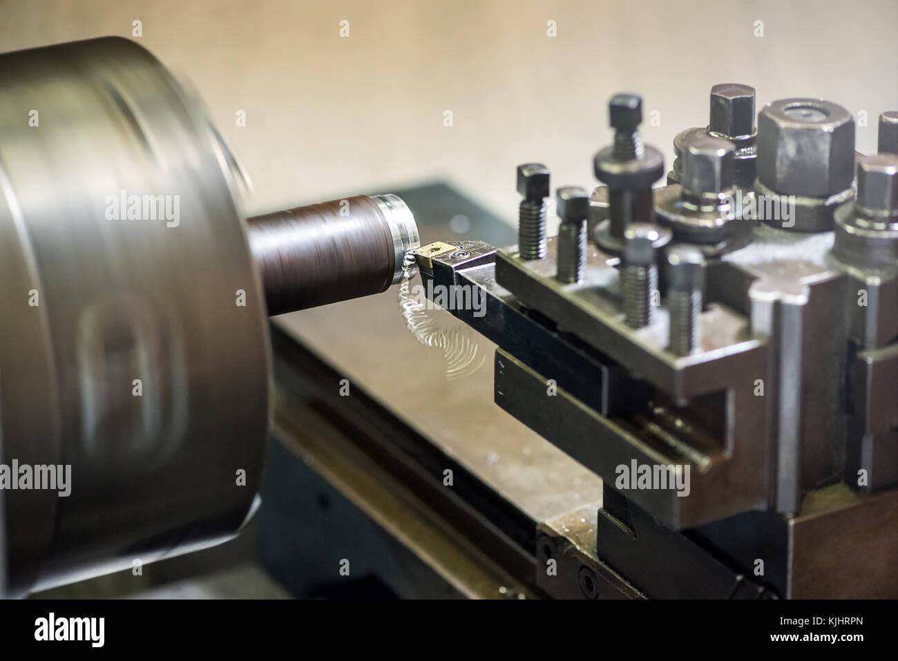 Lathe machine in an industrial workshop with tools and dies and a component in the chuck being milled Stock Photo