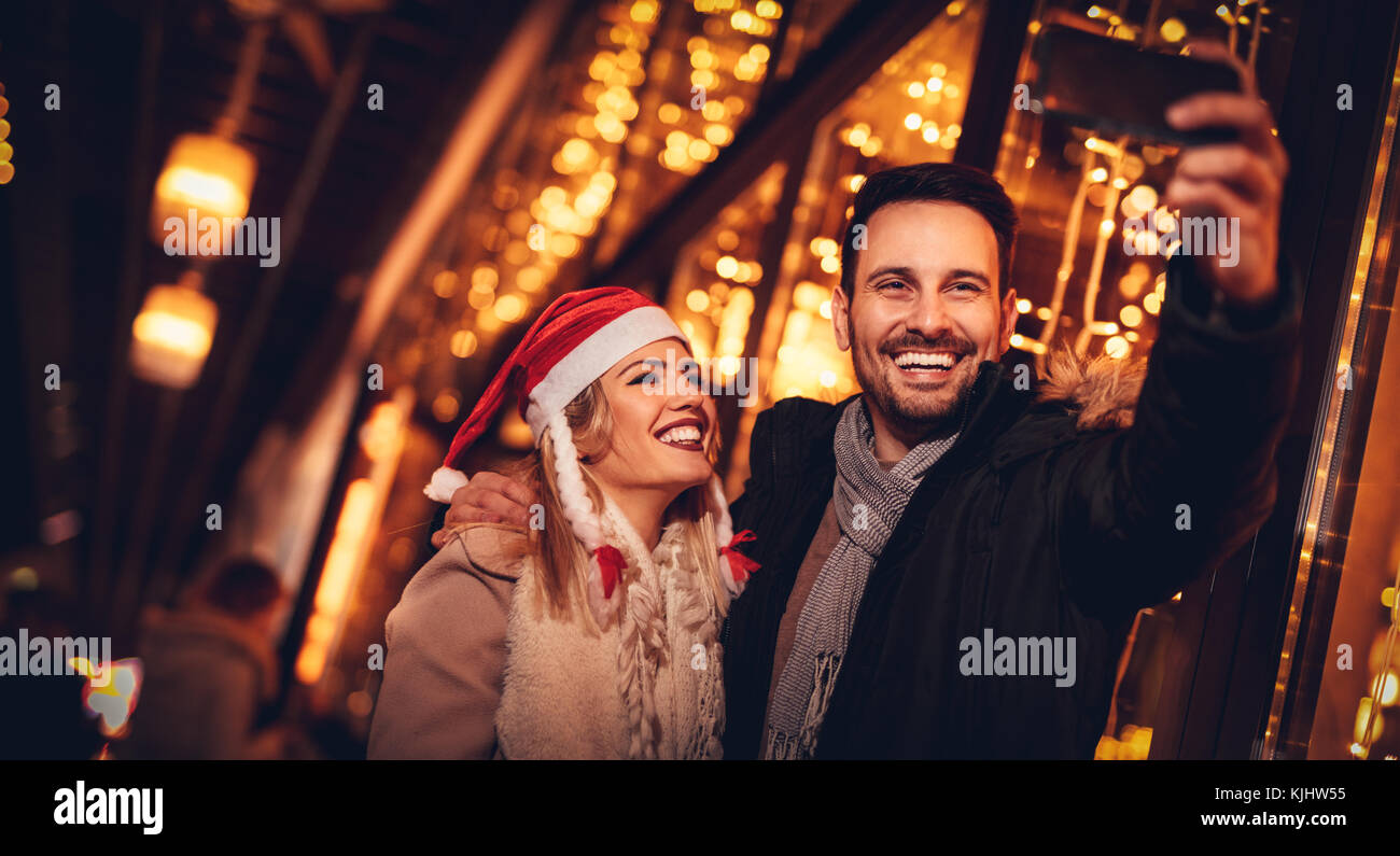Young beautiful cheerful couple taking a selfie in the city street at ...