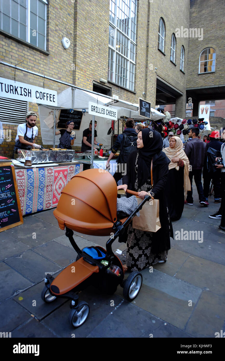 Islamic woman with pram in the Brick Lane Market area in Shoreditch, London, England Stock Photo
