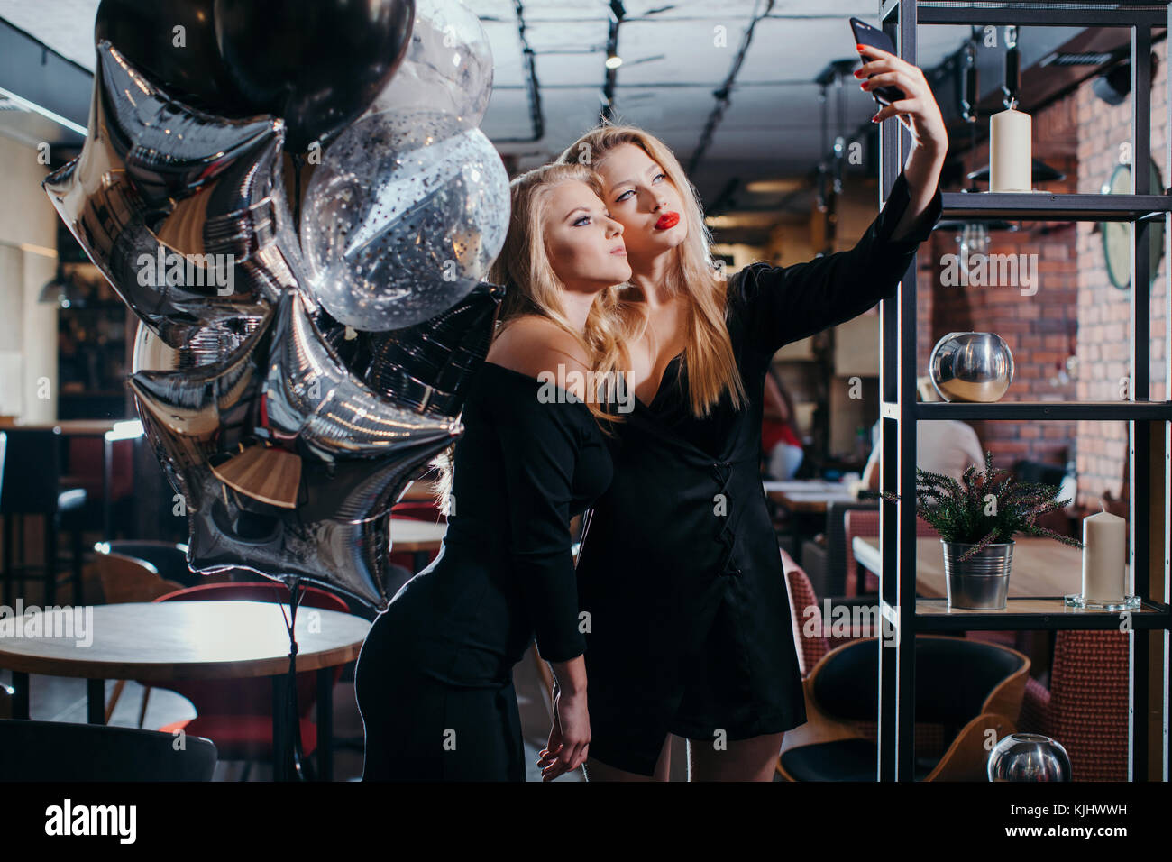 Two women taking selfies in a cafe Stock Photo